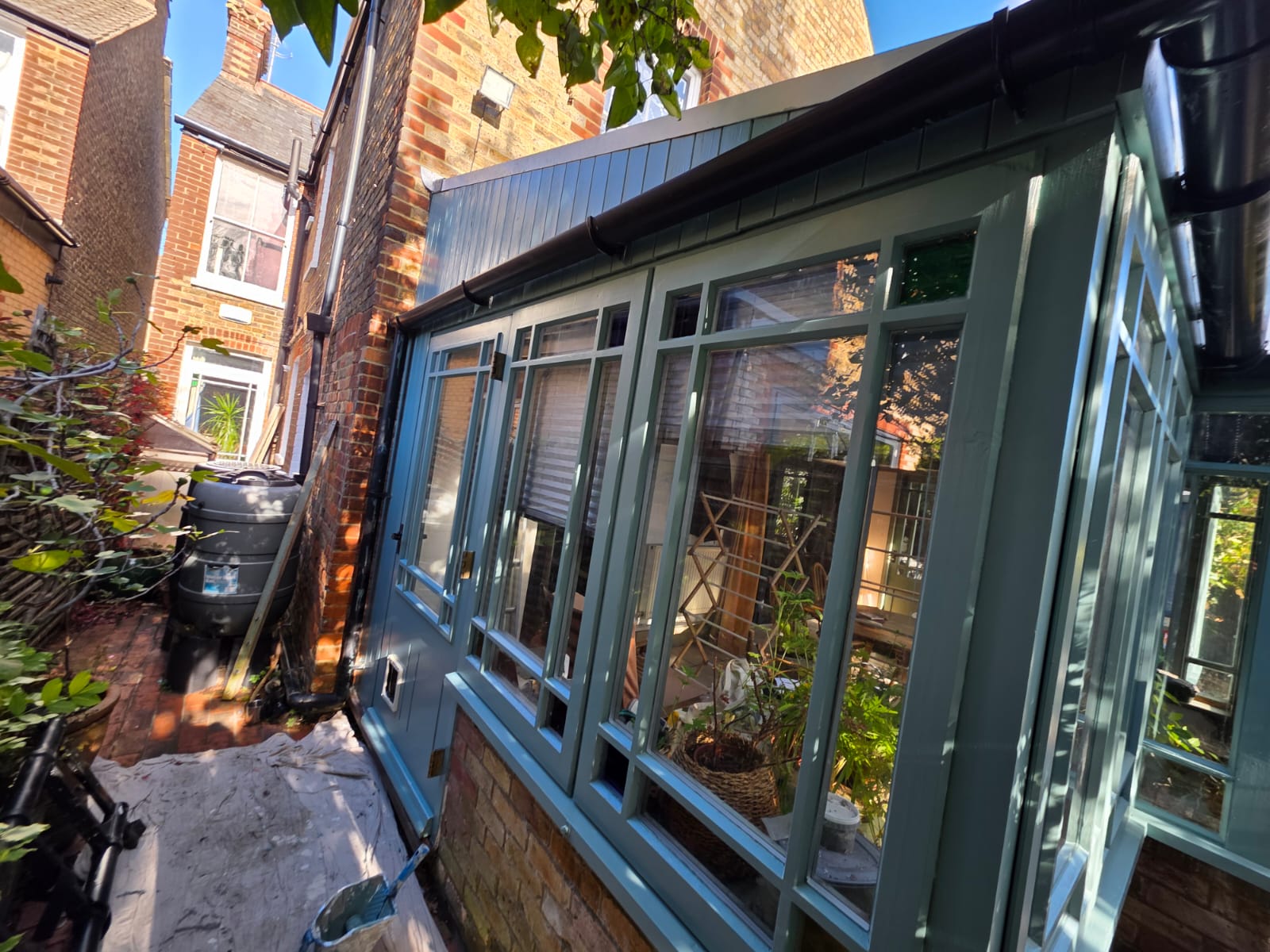 Side of the conservatory after repainting in sage green