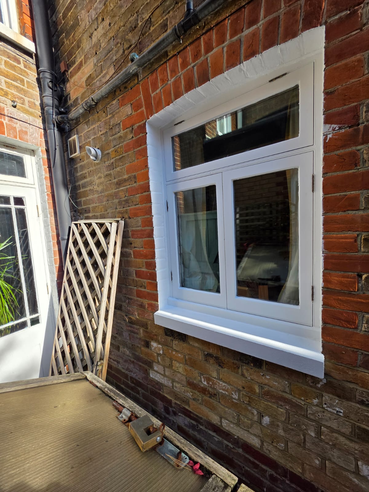Window and reveal repainted in white beside the conservatory