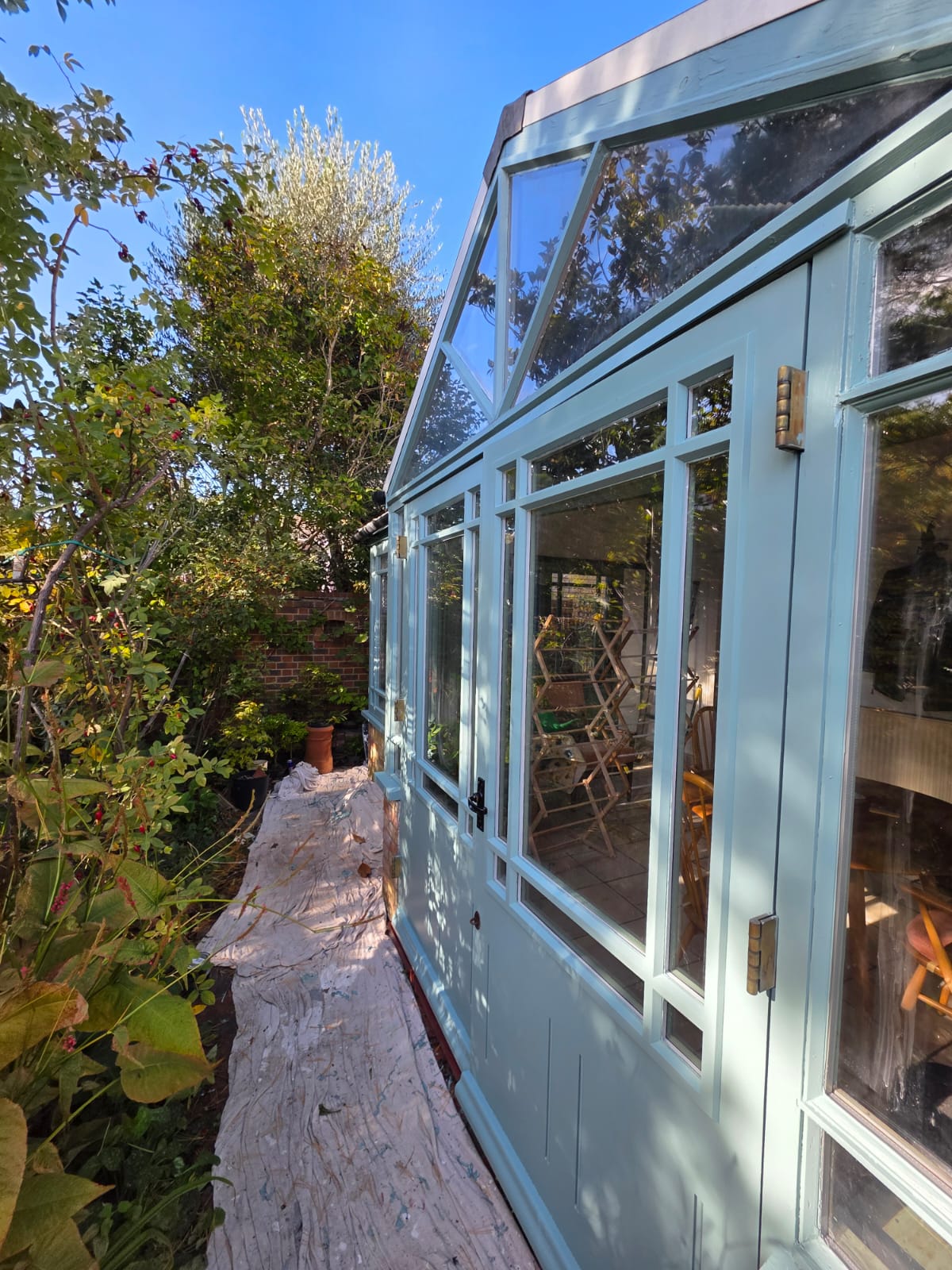 Conservatory frames along the garden path after repainting