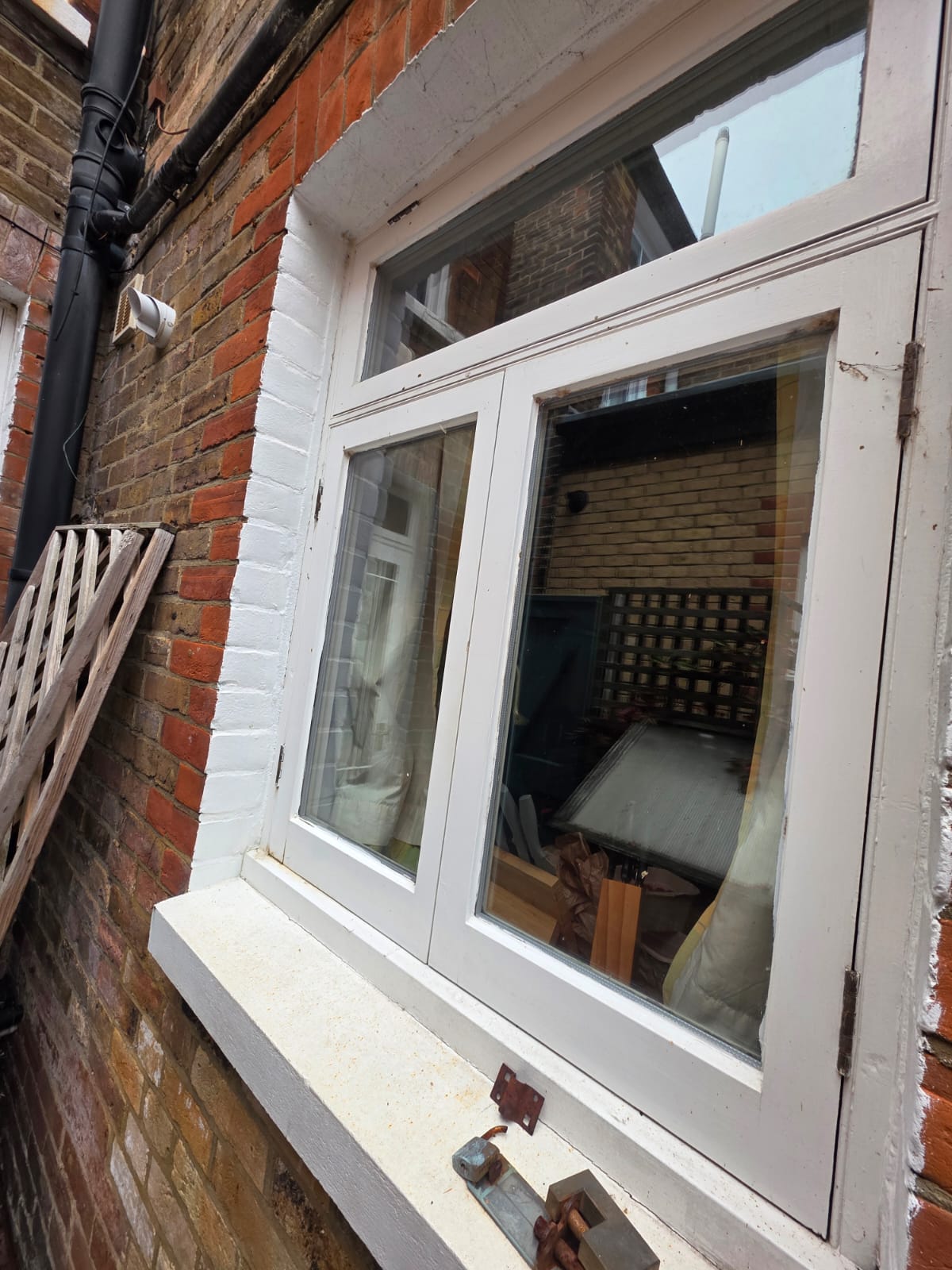 Rear window before, with worn paint and a stained sill