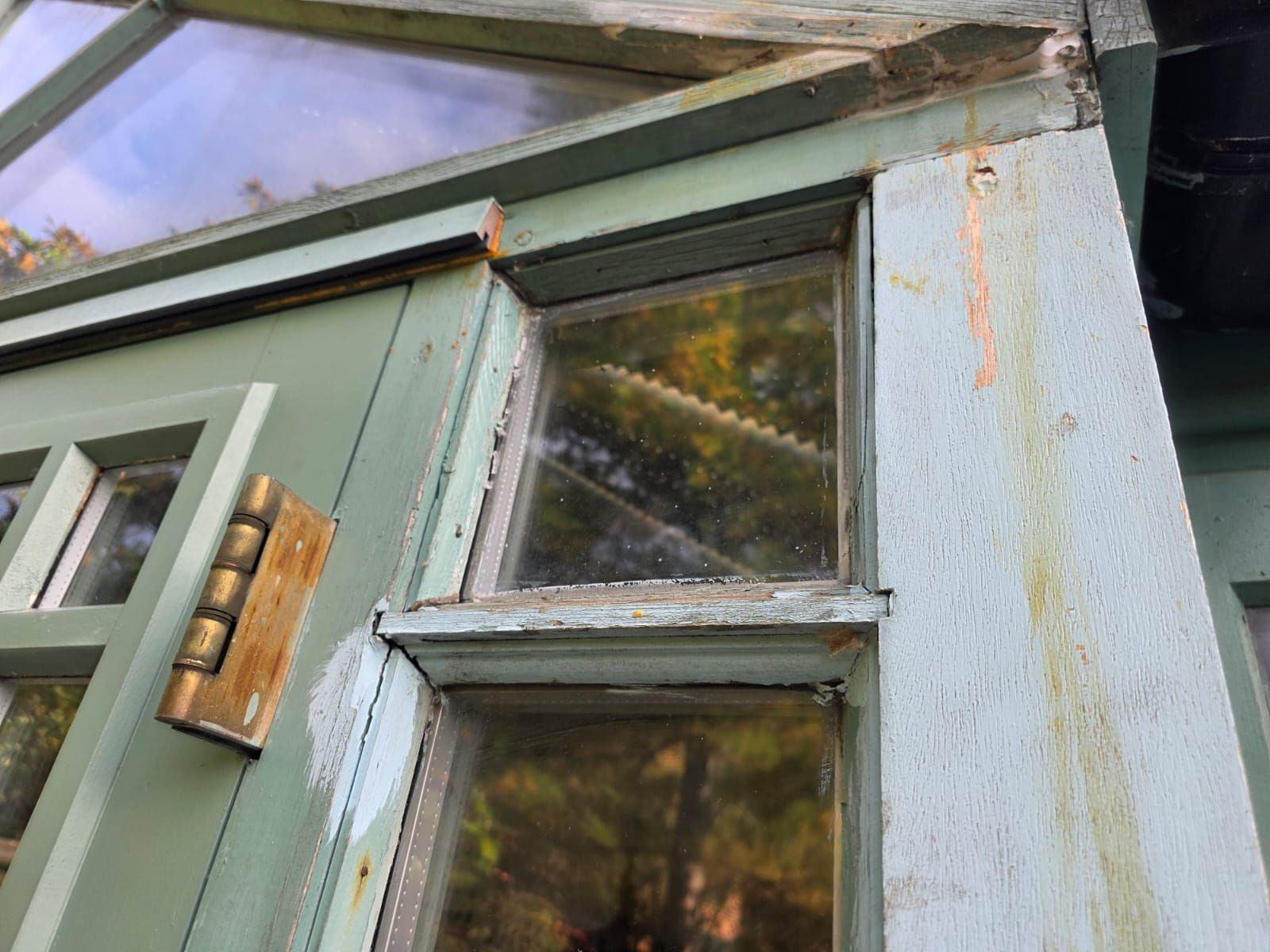 Conservatory door frame before, with worn paint and metal hinge