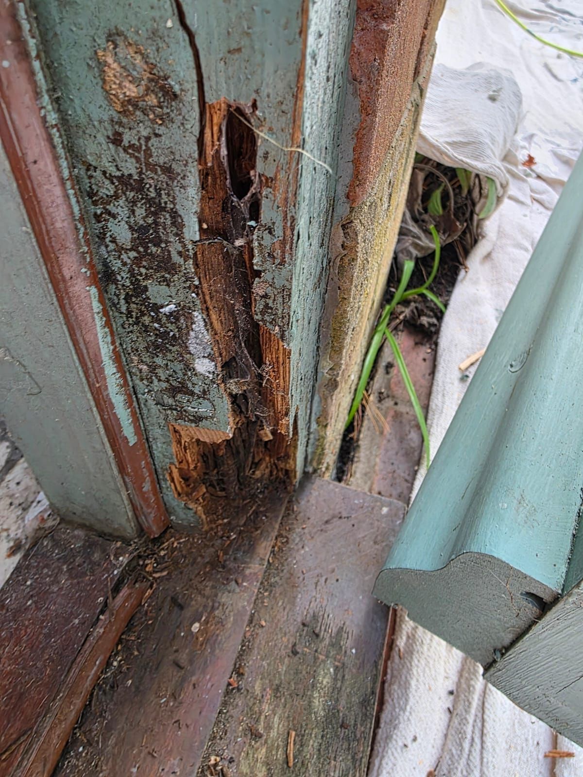 Door frame before, with deep rot at the bottom