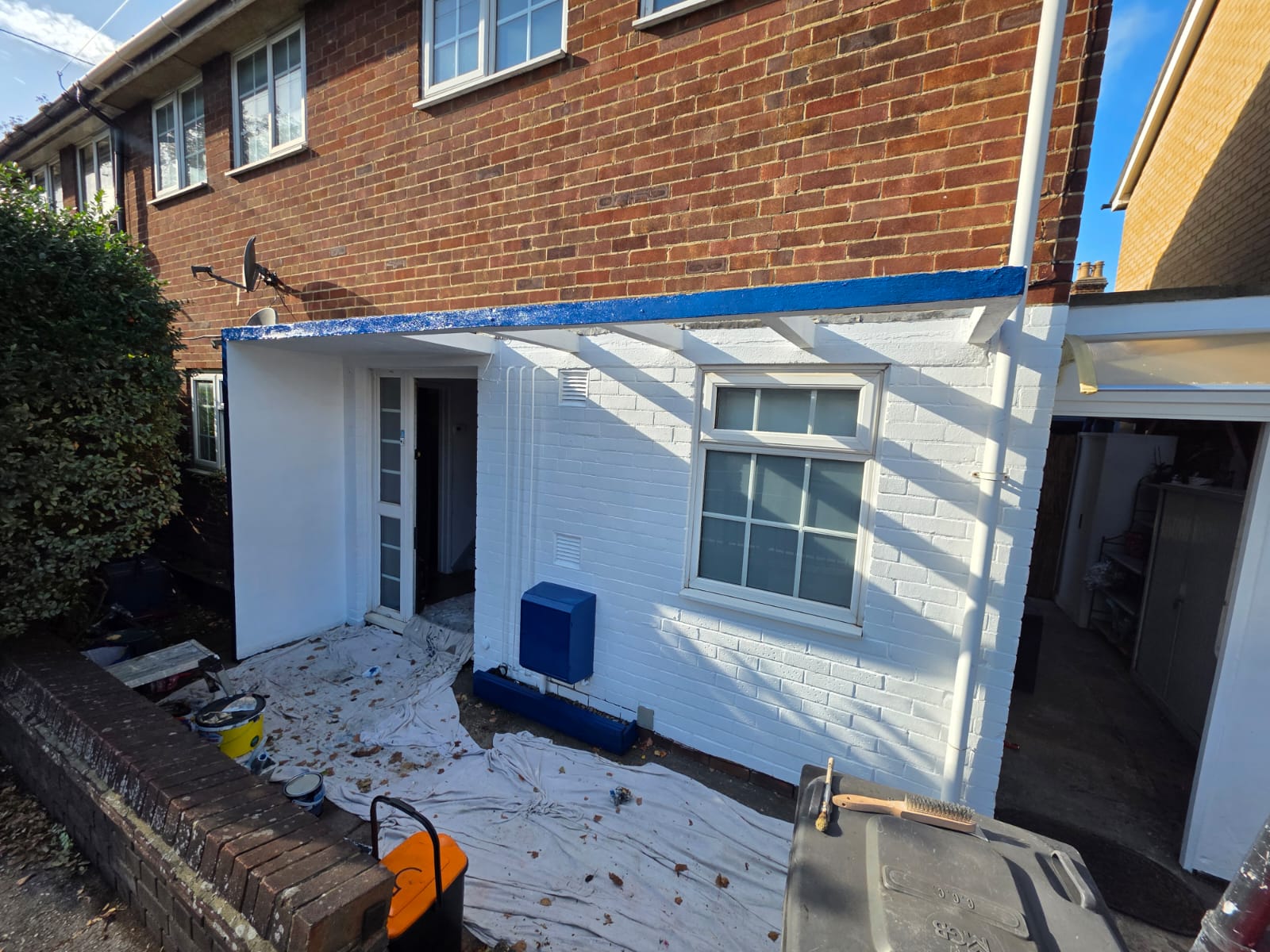 Front elevation finished: painted walls, canopy and blue front door