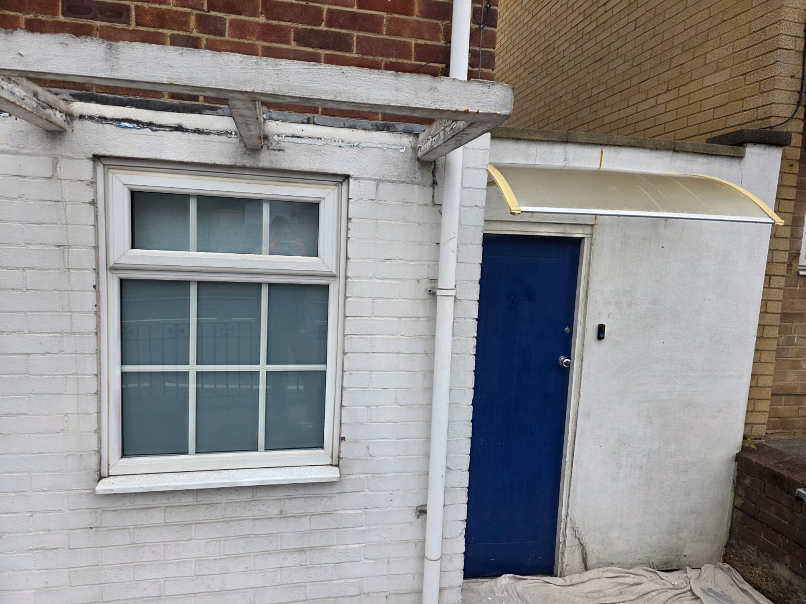 Front of the house before, with tired paint and canopy