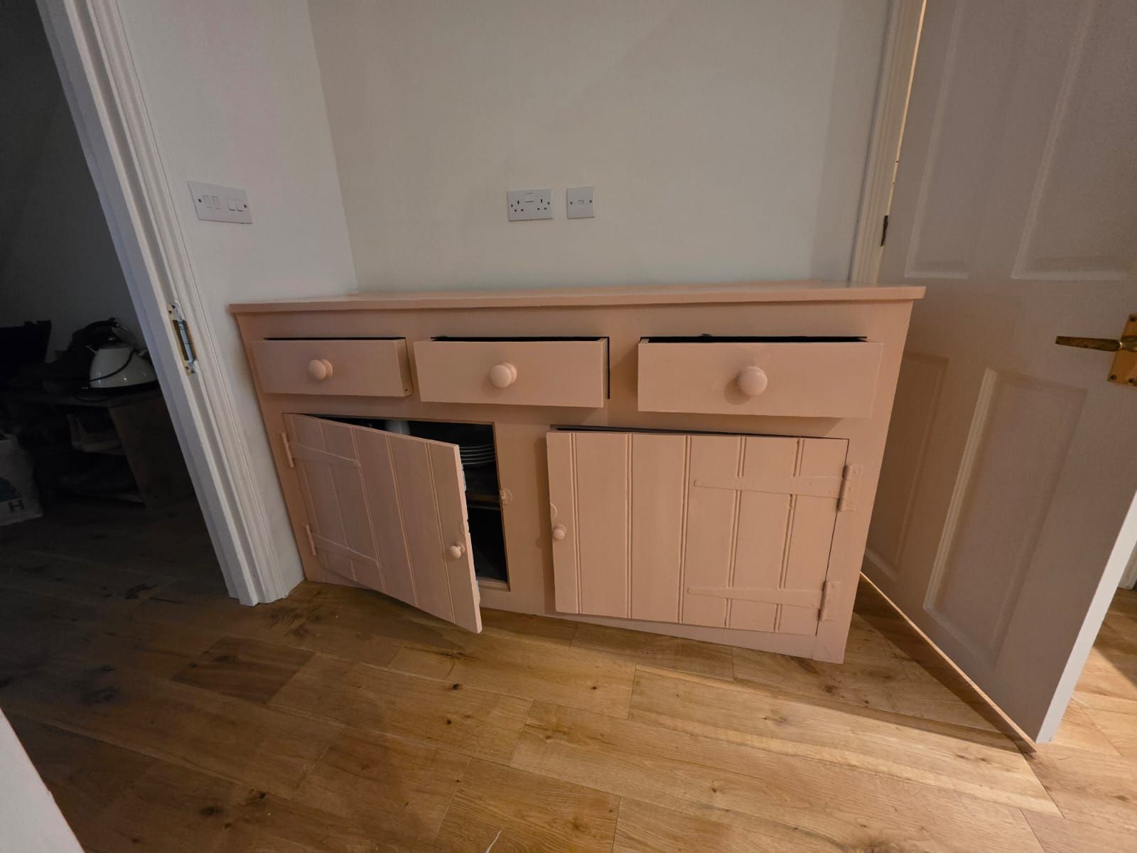 Built-in cupboard finished in soft plaster pink