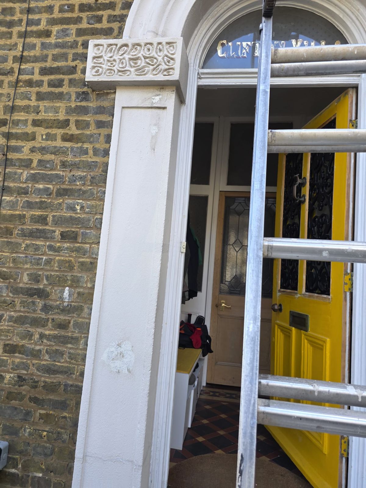 Arched door surround repainted, with the yellow front door