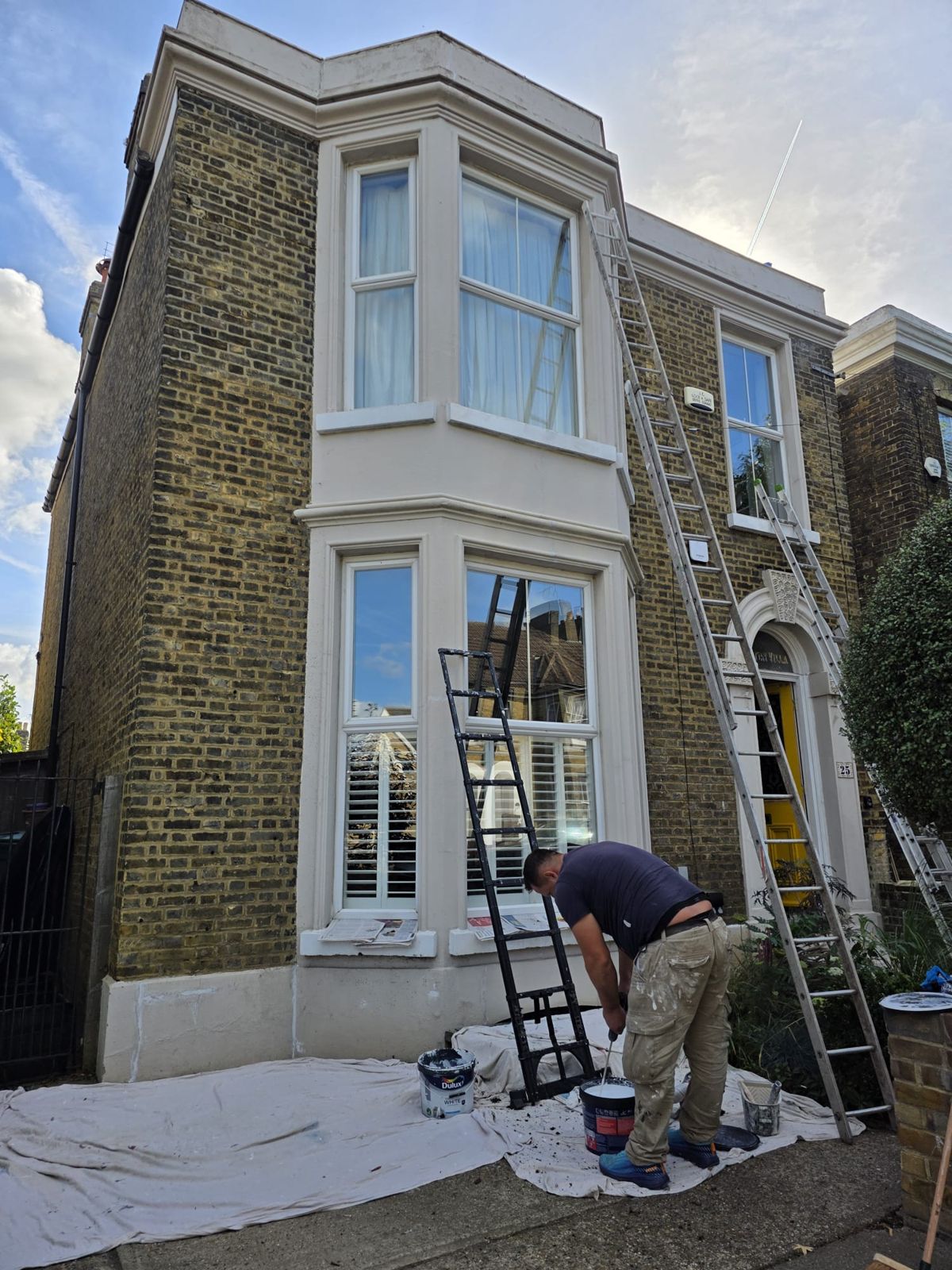 Painting the front with ladders and dust sheets down