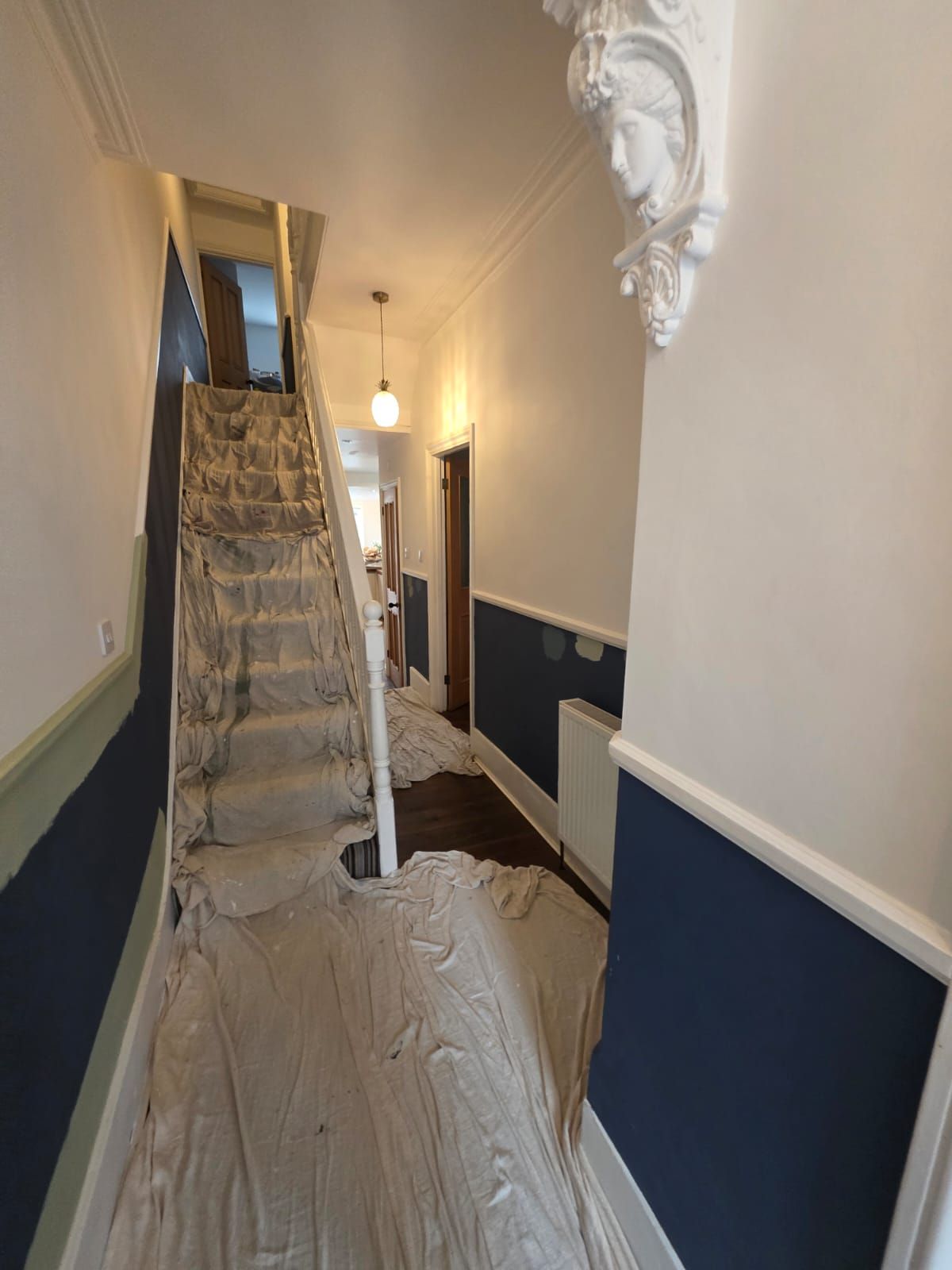Hallway mid-change from navy to sage green