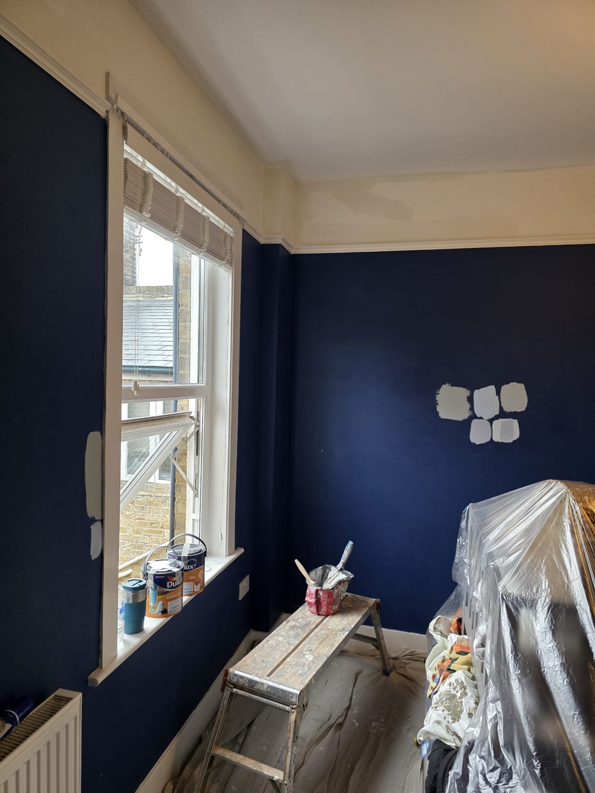 Navy bedroom with sample patches, during the job